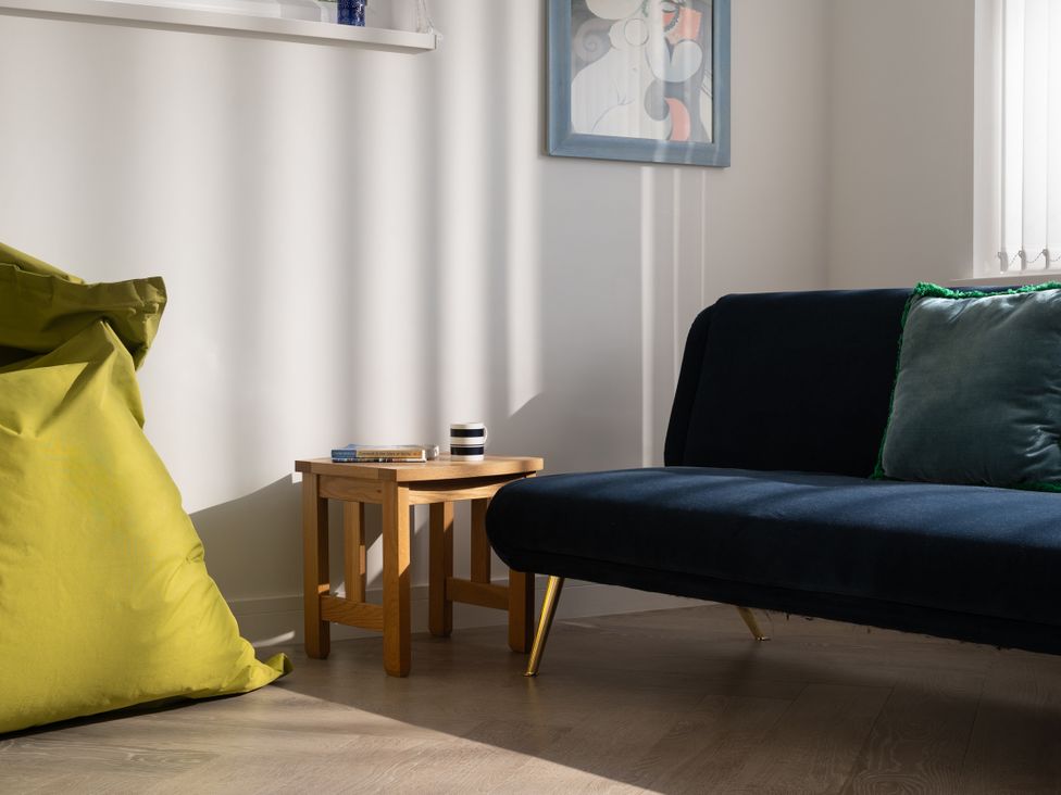 A living room with a sofa and a table at Estuary Watch Lelant near Carbis Bay