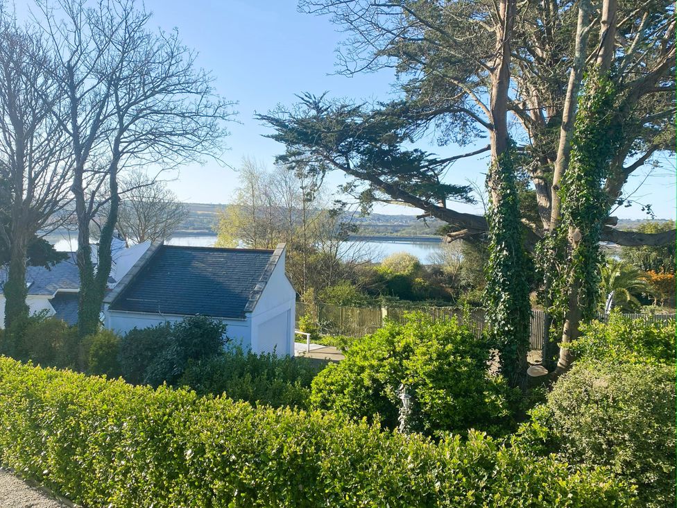 A view of trees and water from a garden at Estuary Watch in Lelant near Carbis Bay