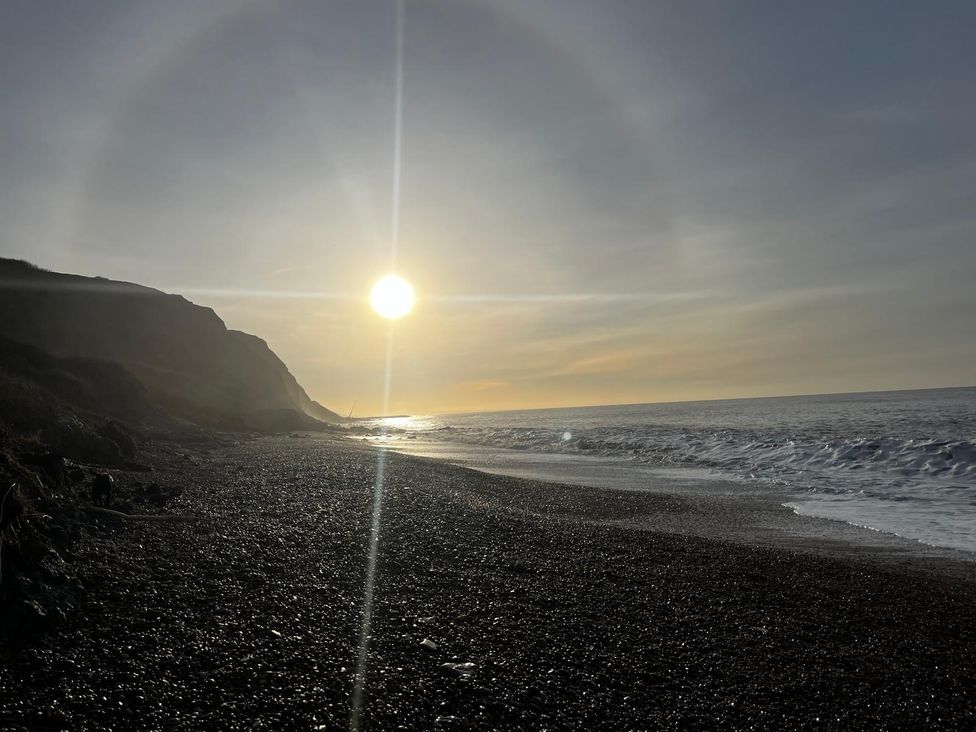 A beach with pebbles and cliffs at Lea Cottage in Eype