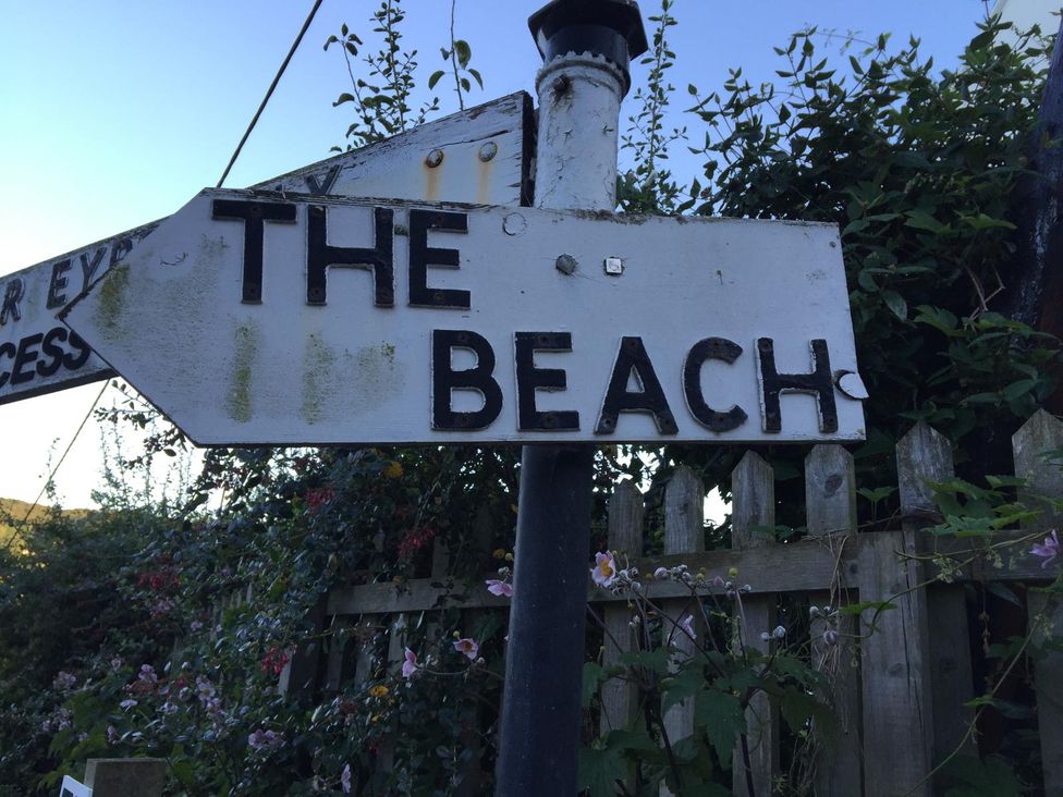 A directional sign pointing to the beach at Lea Cottage in Eype