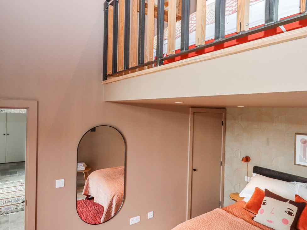 A bedroom with a bed and mirror at 3 Caddaford Barns in Buckfastleigh