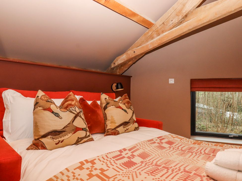 A bedroom with a bed and pillows at 3 Caddaford Barns in Buckfastleigh