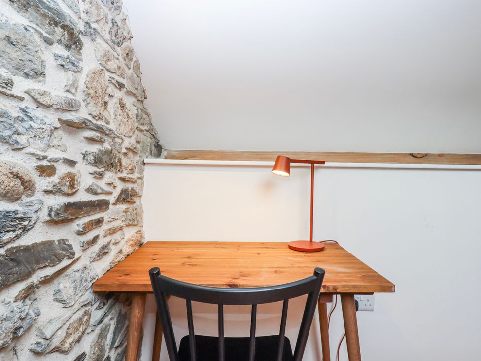 A workspace with a desk and a lamp at 3 Caddaford Barns Buckfastleigh