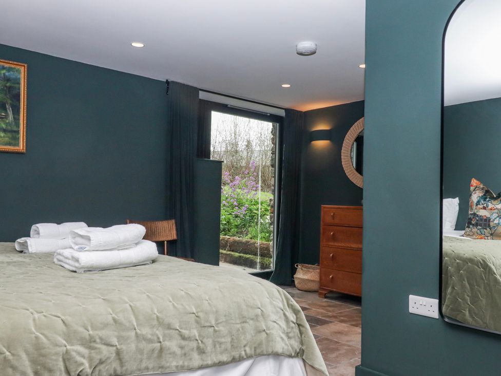 A bedroom with a bed and dressing table at 3 Caddaford Barns in Buckfastleigh