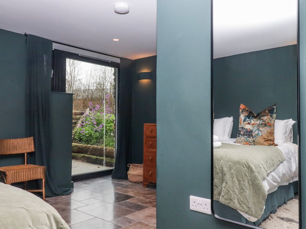 A bedroom with a bed and dresser at 3 Caddaford Barns Buckfastleigh