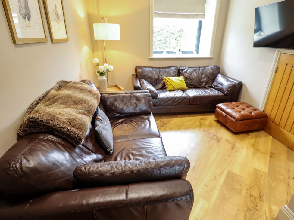 A living room with sofas and an ottoman at Fox's Den in Burton Pidsea