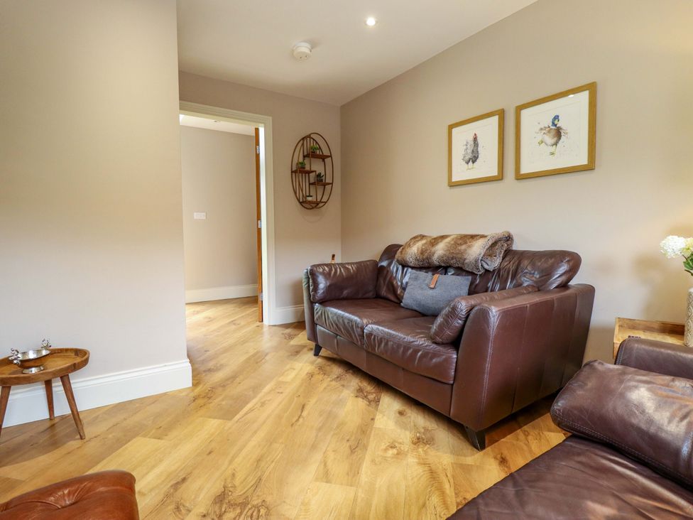 A living room with a sofa and artwork on the wall at Fox's Den in Burton Pidsea