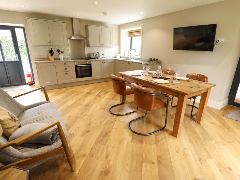 A kitchen with a dining area and sofa at Fox's Den in Burton Pidsea