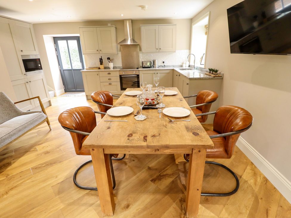 A kitchen with a dining table and chairs at Fox's Den in Burton Pidsea