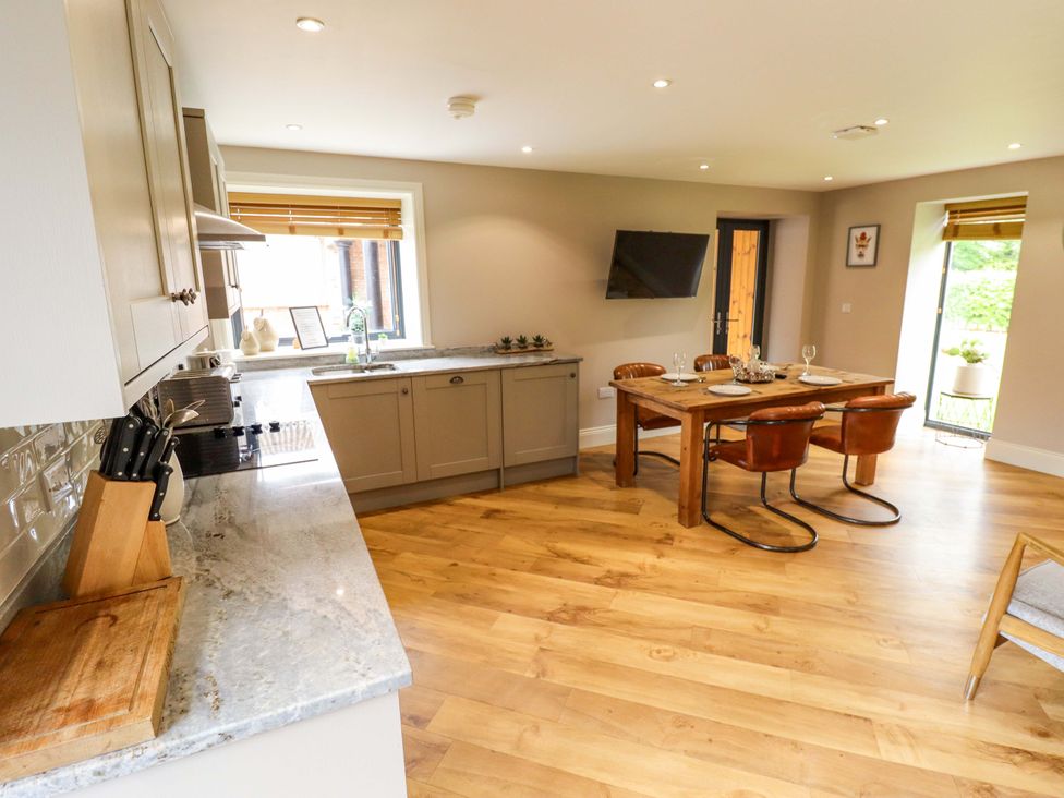 A kitchen with a dining table and chairs at Fox's Den in Burton Pidsea
