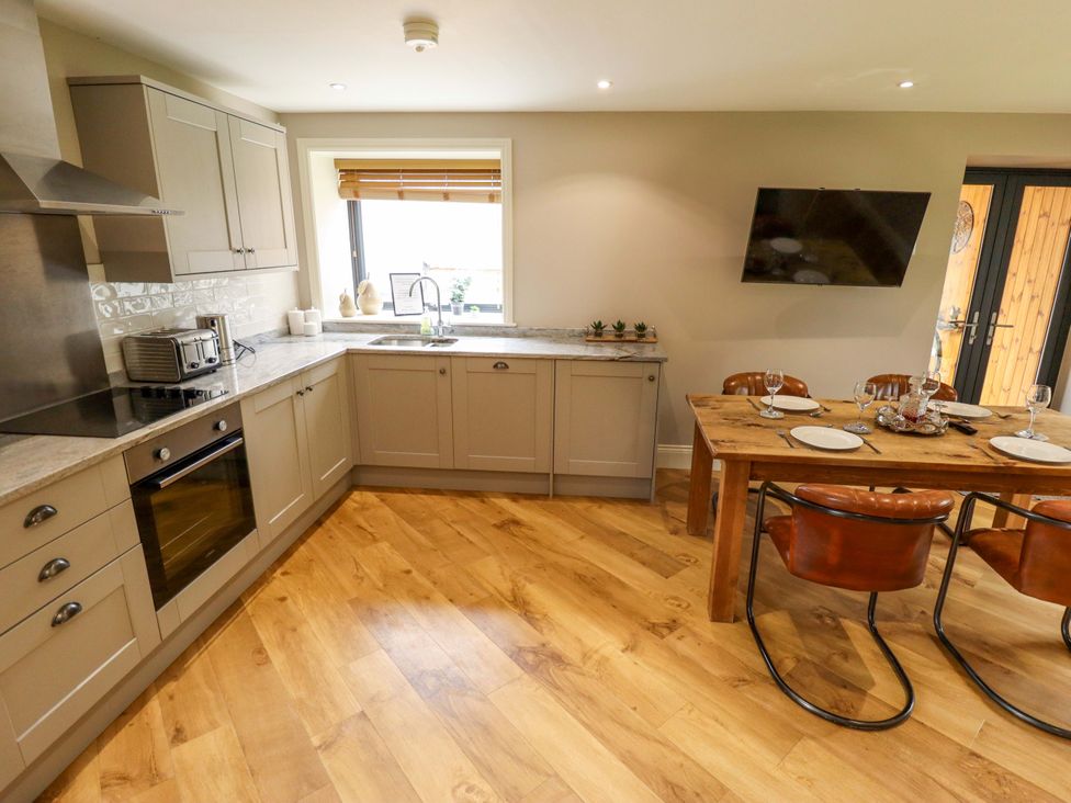 A kitchen with dining table and appliances at Fox's Den in Burton Pidsea
