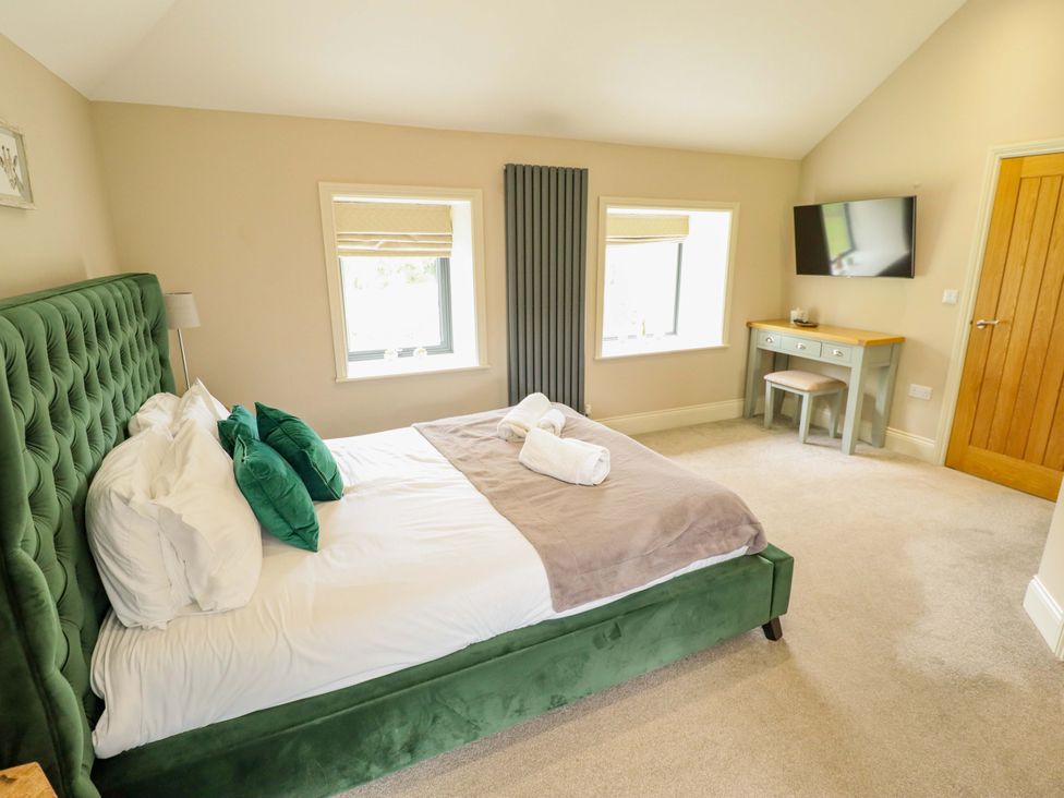 A bedroom with a bed and desk at Fox's Den in Burton Pidsea