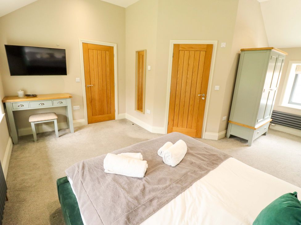A bedroom with a bed, television and wardrobe at Fox's Den in Burton Pidsea
