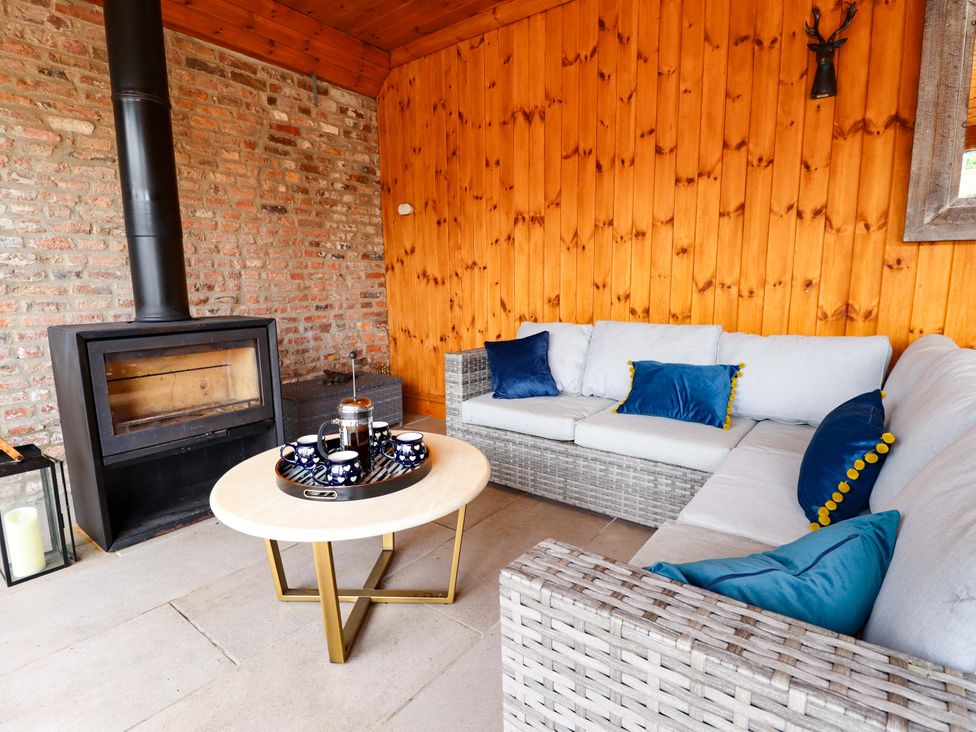 A snug area with a sofa and a fireplace at Fox's Den in Burton Pidsea