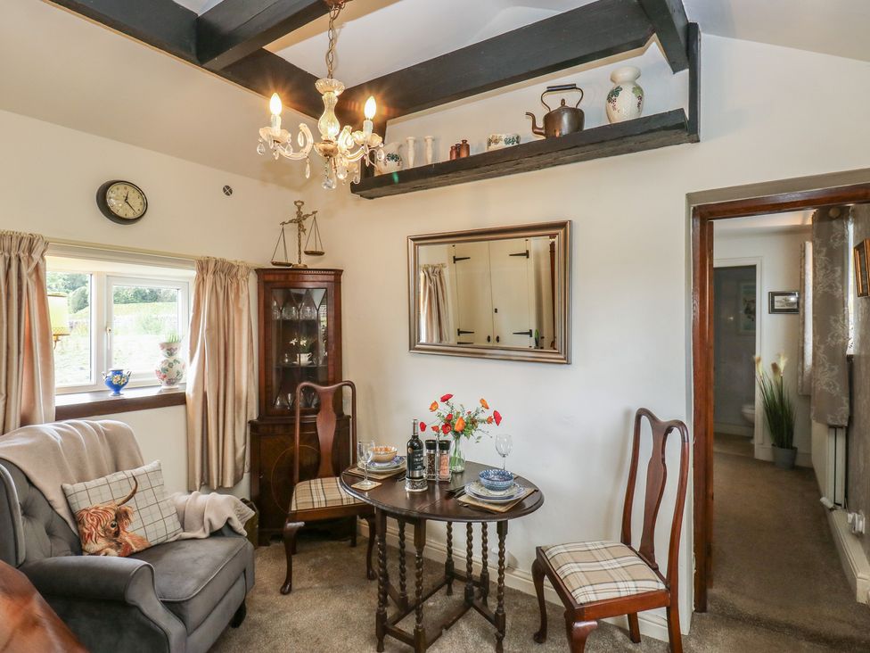 A living room with a dining table and chairs at Prospect Cottage in Ripponden