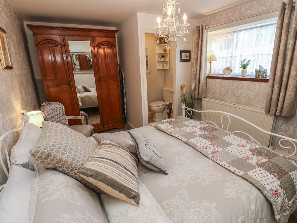 A bedroom with a bed and wardrobe at Prospect Cottage in Ripponden