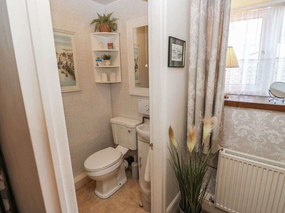 A bathroom with a toilet and mirror at Prospect Cottage in Ripponden