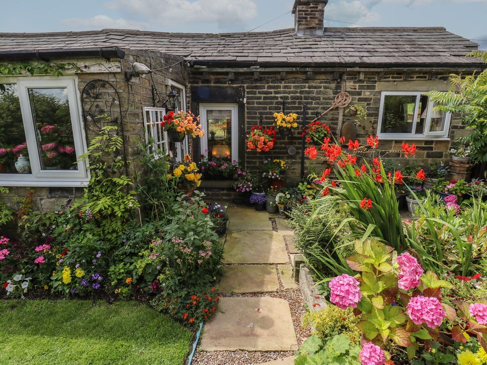 A garden with flowers and a path at Prospect Cottage in Ripponden