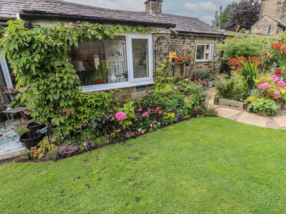 A garden with flowers and grass at Prospect Cottage in Ripponden