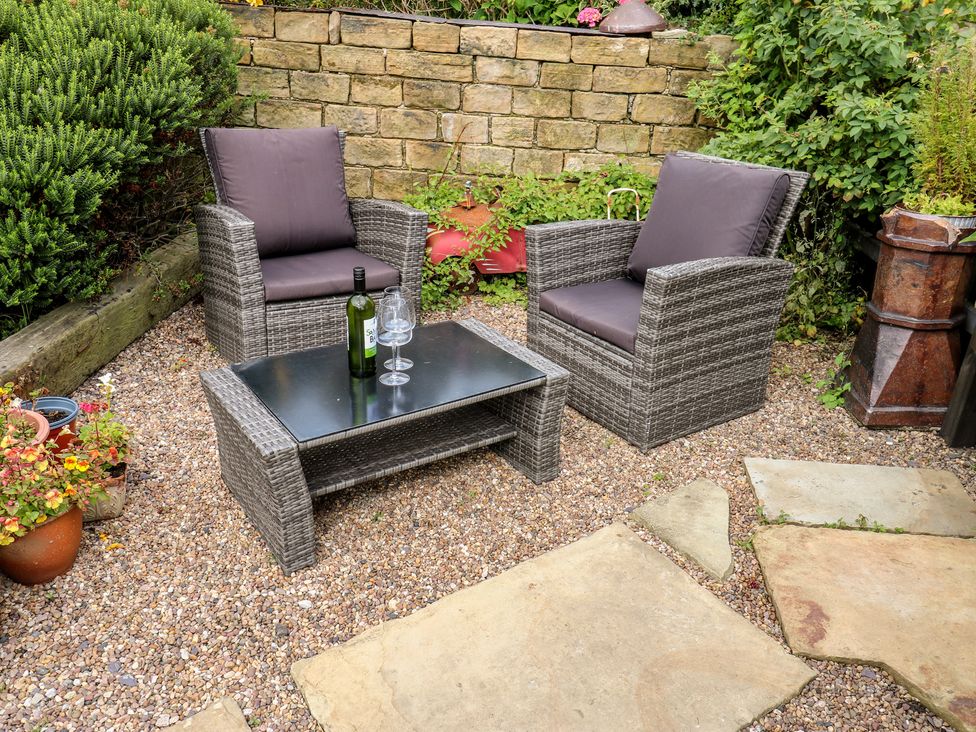 A garden area with outdoor seating and a coffee table at Prospect Cottage in Ripponden