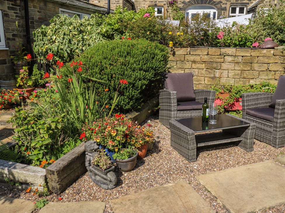 A garden with seating and a small table at Prospect Cottage in Ripponden