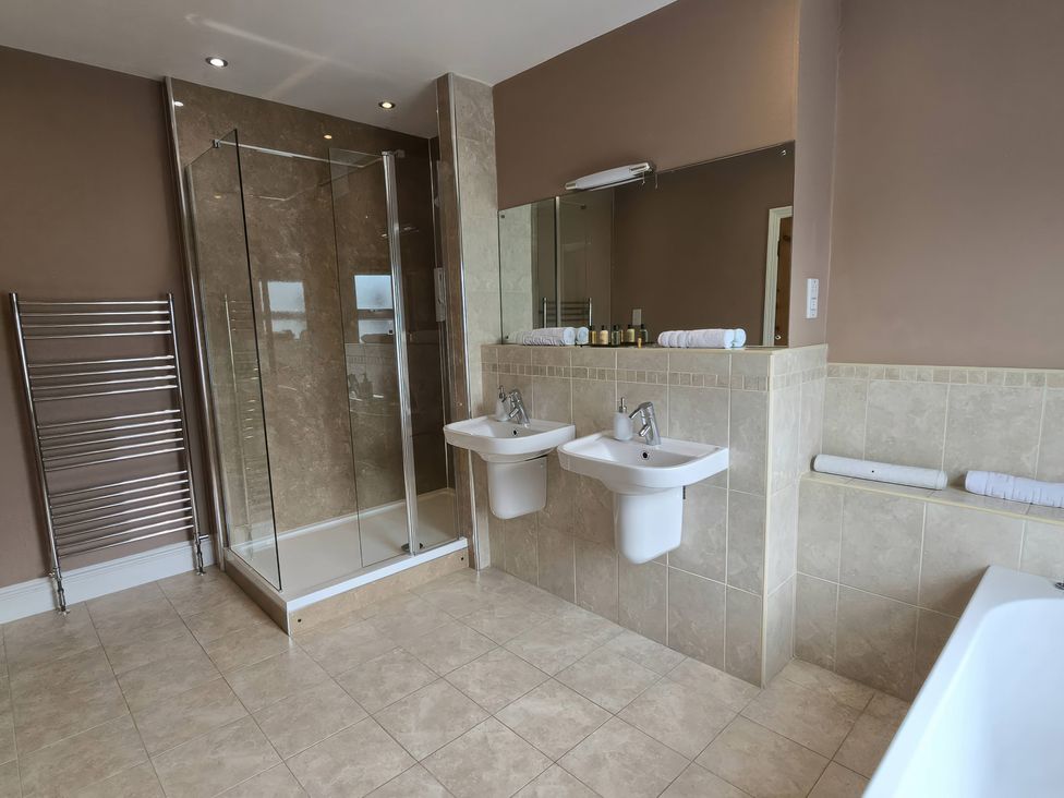 A bathroom with dual washbasins and a shower at Derwent Cottage in Keswick