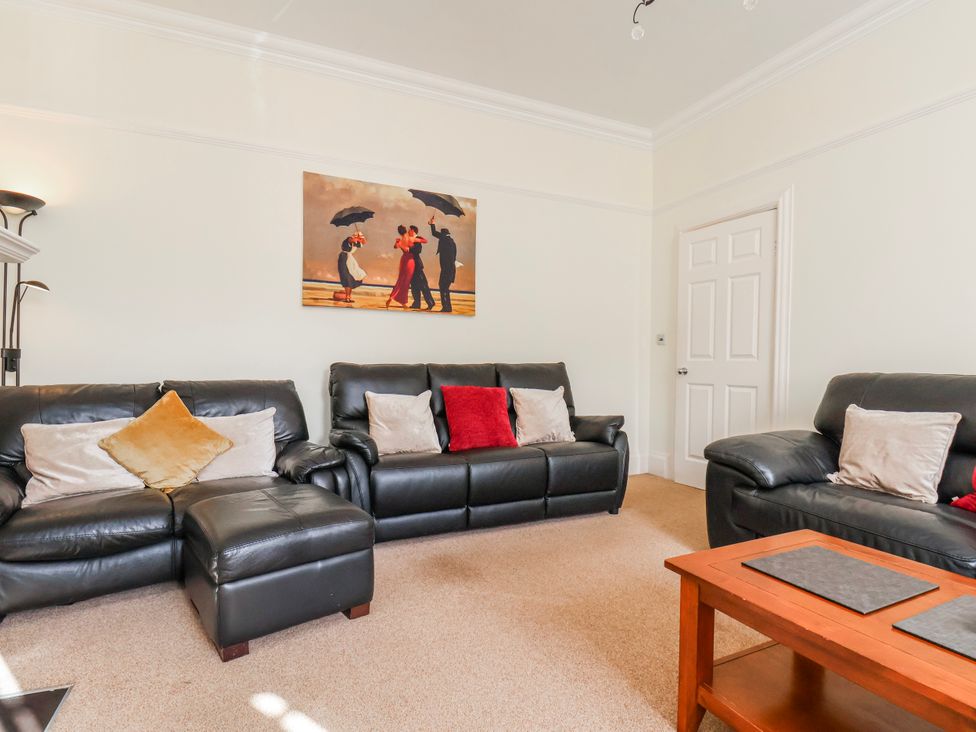 A living room with leather sofas and a coffee table at 50 West Street Edelweiss in Scarborough