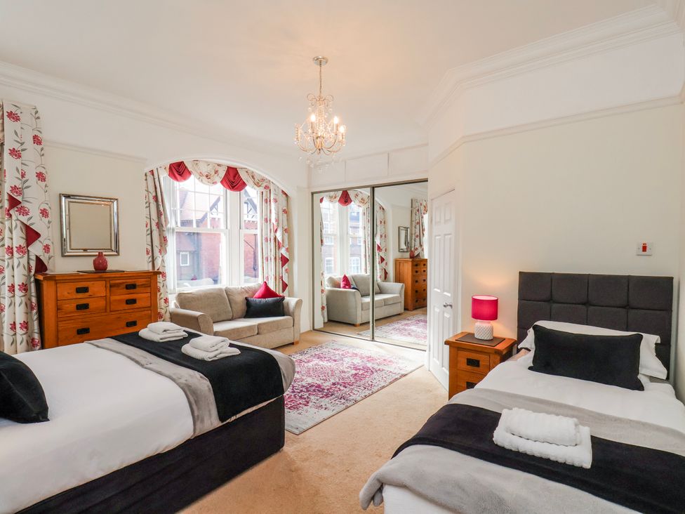 A bedroom featuring two beds and a sofa at 50 West Street Edelweiss Scarborough