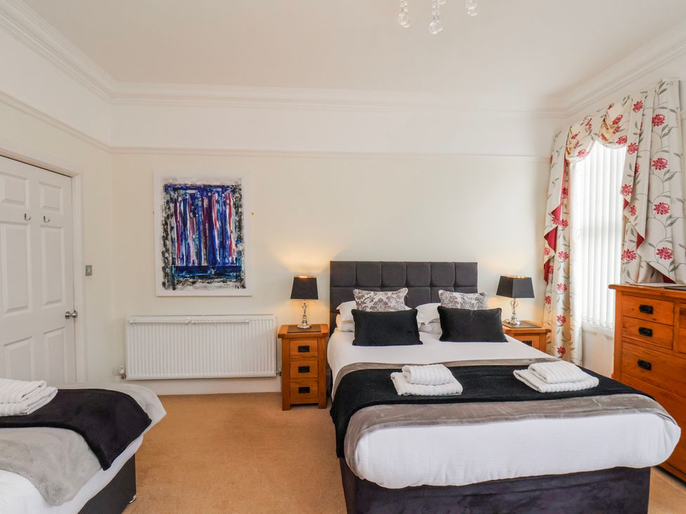 A bedroom with a bed and wardrobe at 50 West Street Edelweiss Scarborough