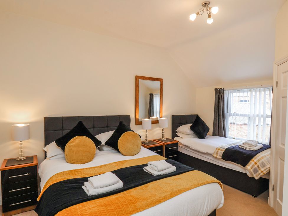 A bedroom with two beds and a mirror at 50 West Street Edelweiss Scarborough