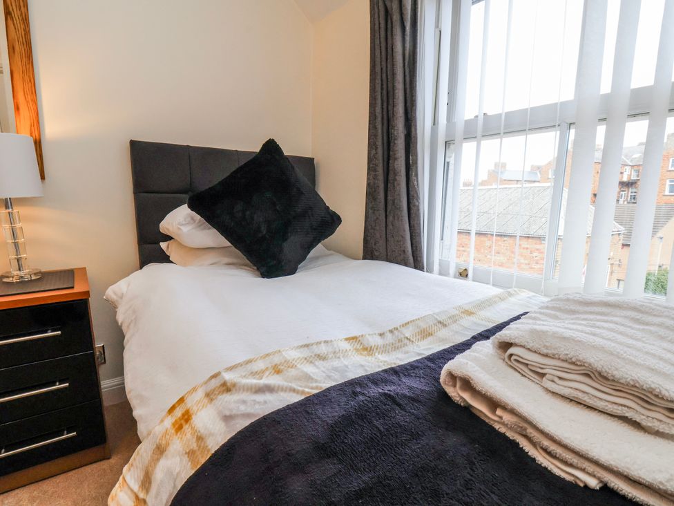 A bedroom with a bed and bedside table at 50 West Street Edelweiss Scarborough