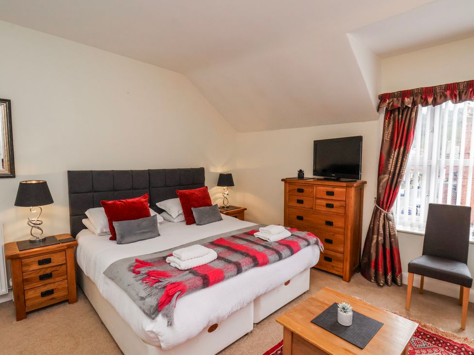 A bedroom with a bed and dresser at 50 West Street Edelweiss in Scarborough