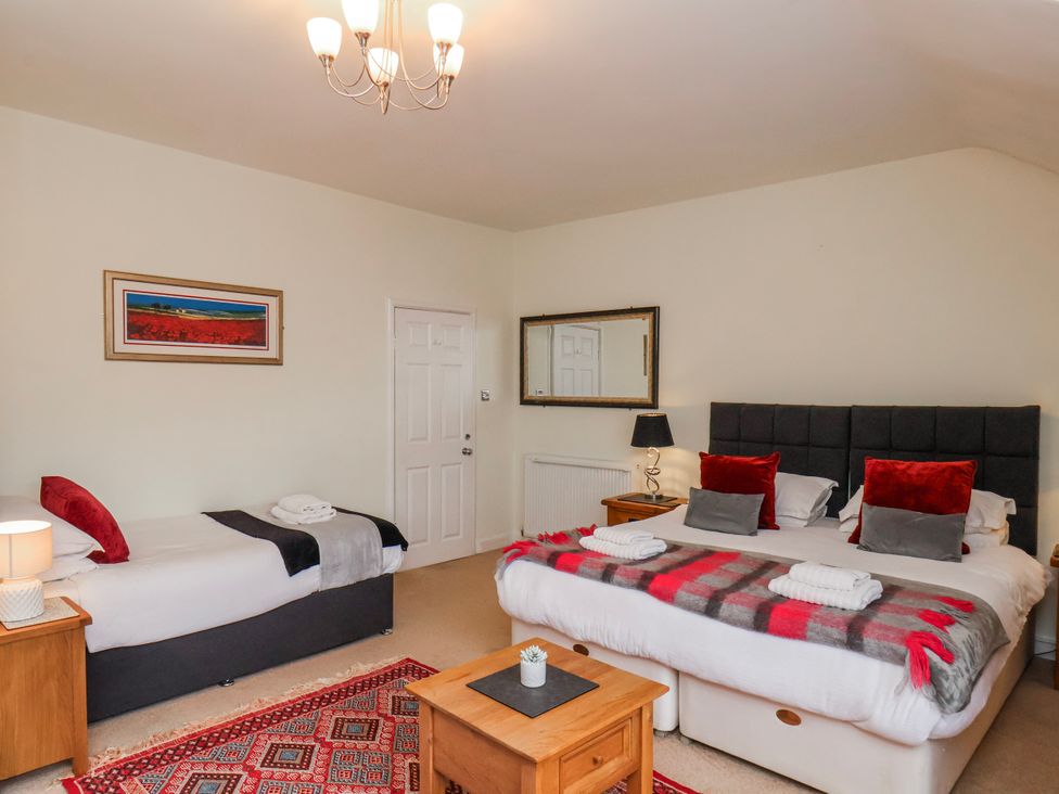 A bedroom with two beds and a table at 50 West Street Edelweiss in Scarborough