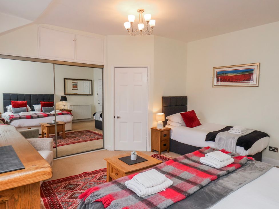 A bedroom with two beds and a mirror at 50 West Street Edelweiss Scarborough