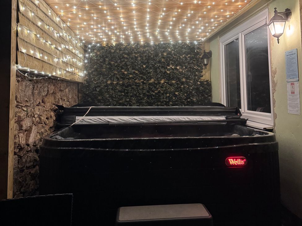 An outdoor area with a hot tub and decorative lights at The Keep in Llandudno