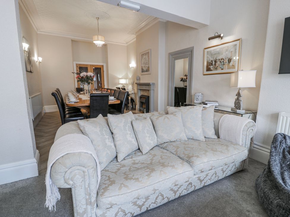 A living room with a sofa and a dining table at The Keep in Llandudno