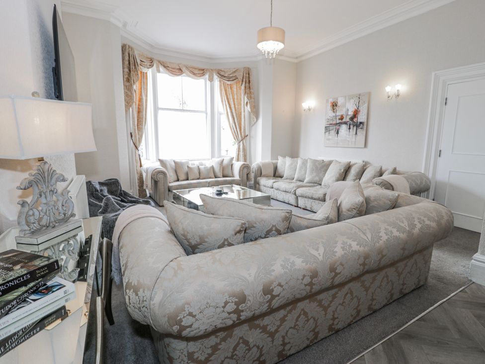 A living room with a large sofa and coffee table at The Keep in Llandudno