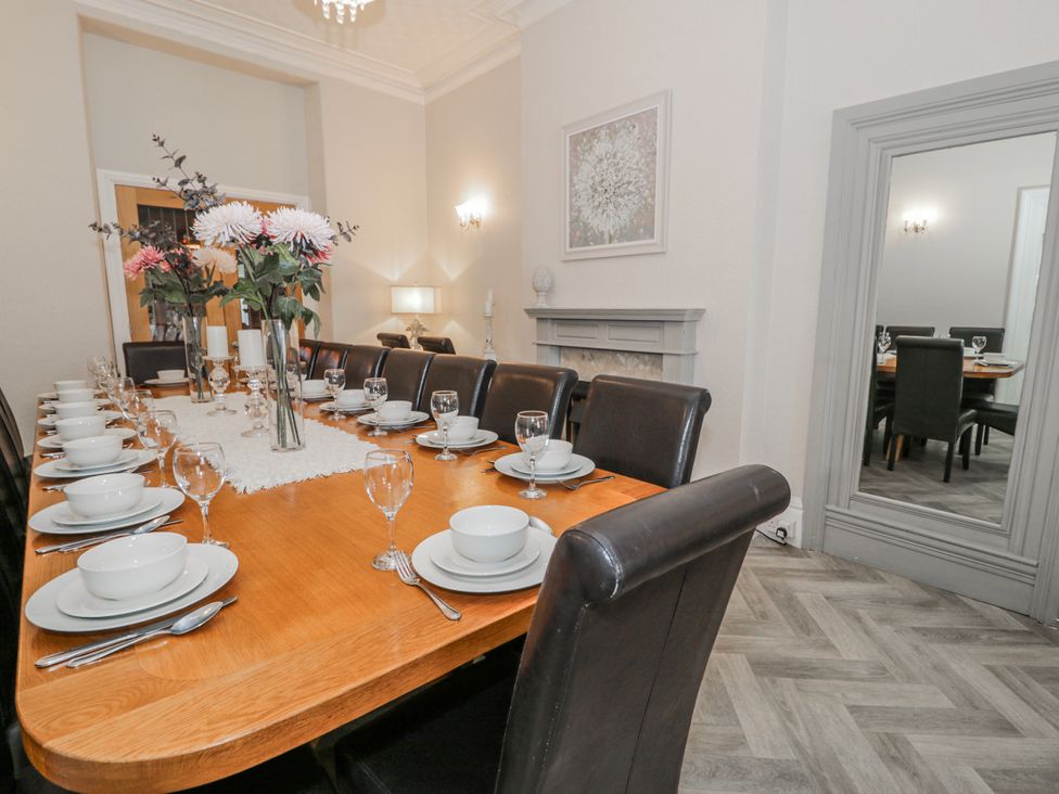 A dining room with a large table set for dinner at The Keep Llandudno