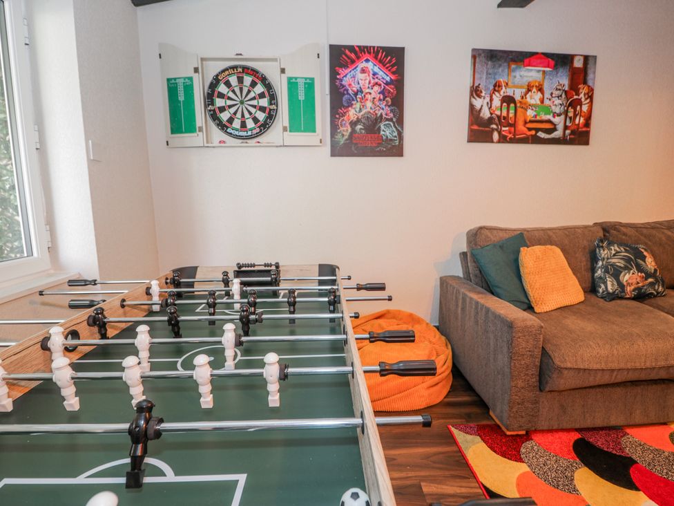 A game room with a foosball table and dartboard at The Keep in Llandudno