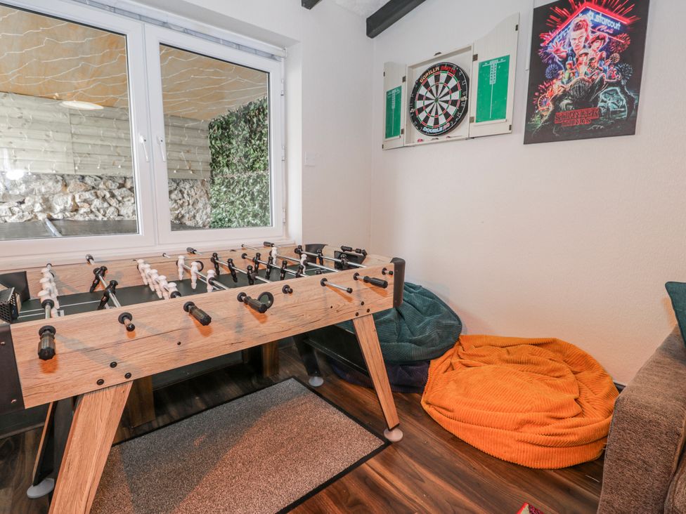 A games room with a foosball table and dartboard at The Keep in Llandudno