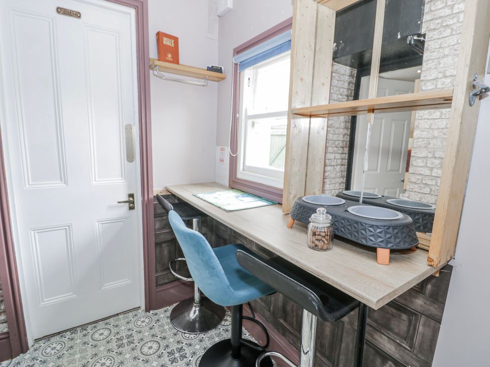A kitchen with a table and chairs at The Keep in Llandudno