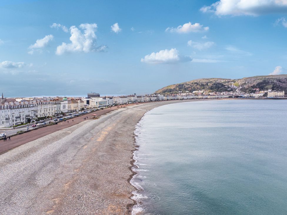 A beach with a promenade and buildings along the shore at The Keep in Llandudno