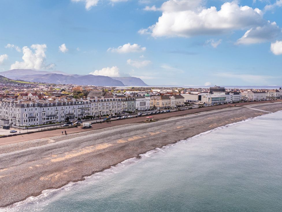 A beach with buildings and cars along the waterfront at The Keep in Llandudno