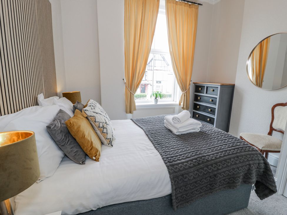 A bedroom with a bed and a dresser at The Keep in Llandudno