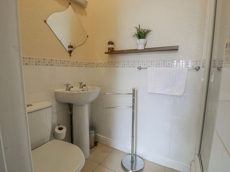 A bathroom featuring a toilet, sink, and shower at The Keep in Llandudno