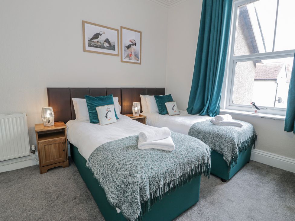 A bedroom with two beds and a window at The Keep in Llandudno