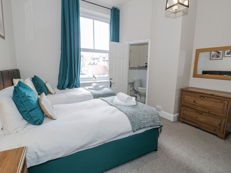 A bedroom with two beds and a window at The Keep in Llandudno