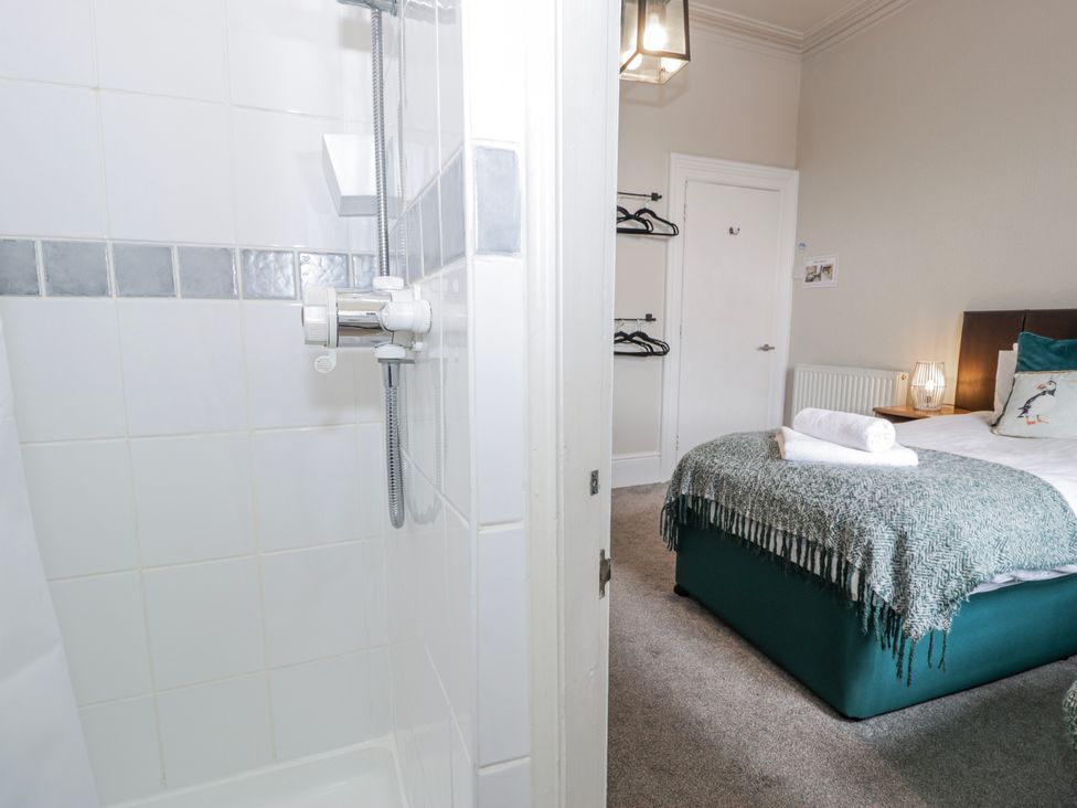 A bedroom with a bed and shower at The Keep in Llandudno