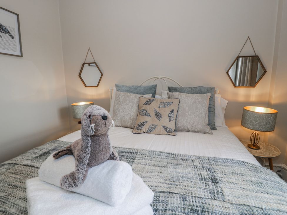 A bedroom with a bed and pillows at The Keep in Llandudno