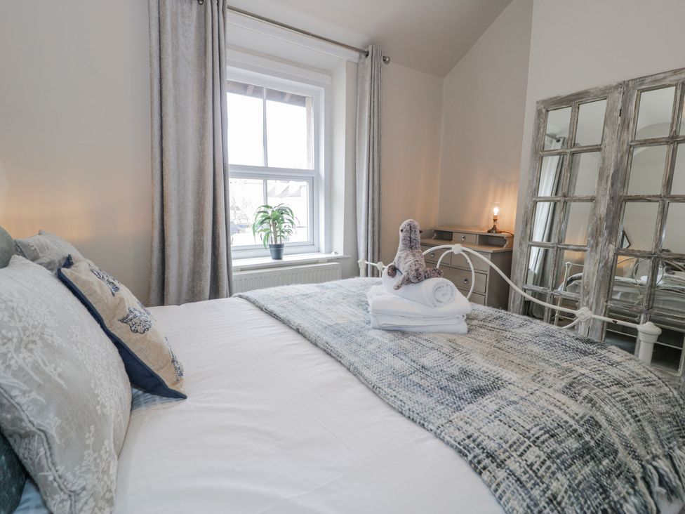 A bedroom with a bed and decorative pillows at The Keep in Llandudno